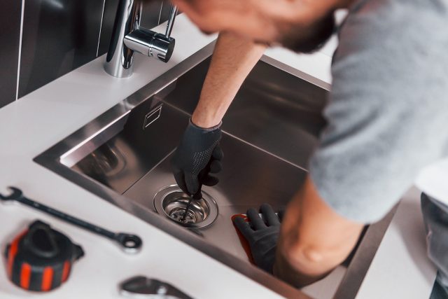 technician inspecting clogged sink